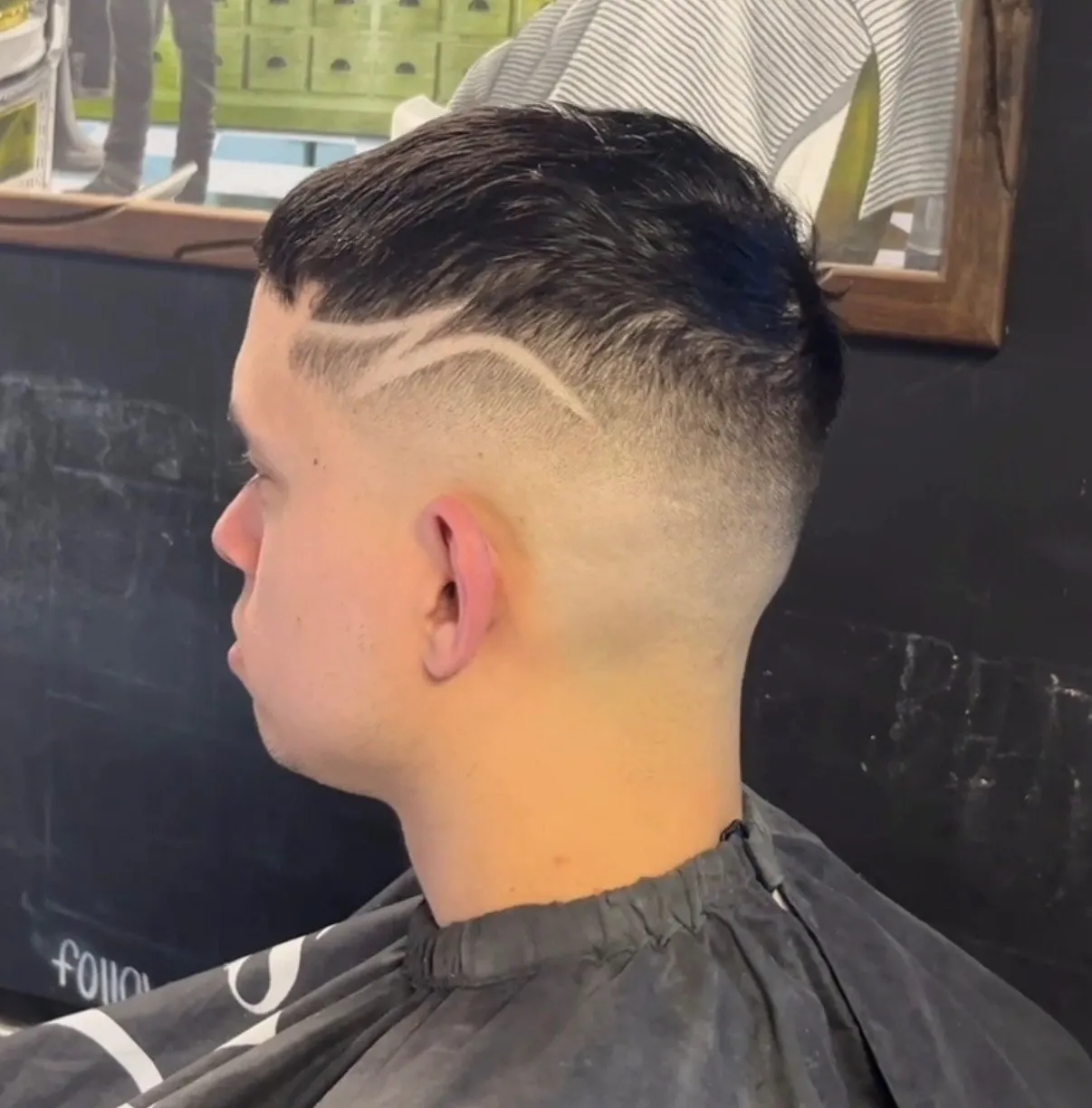 Drop fade with a freehand hard part design carved into the side